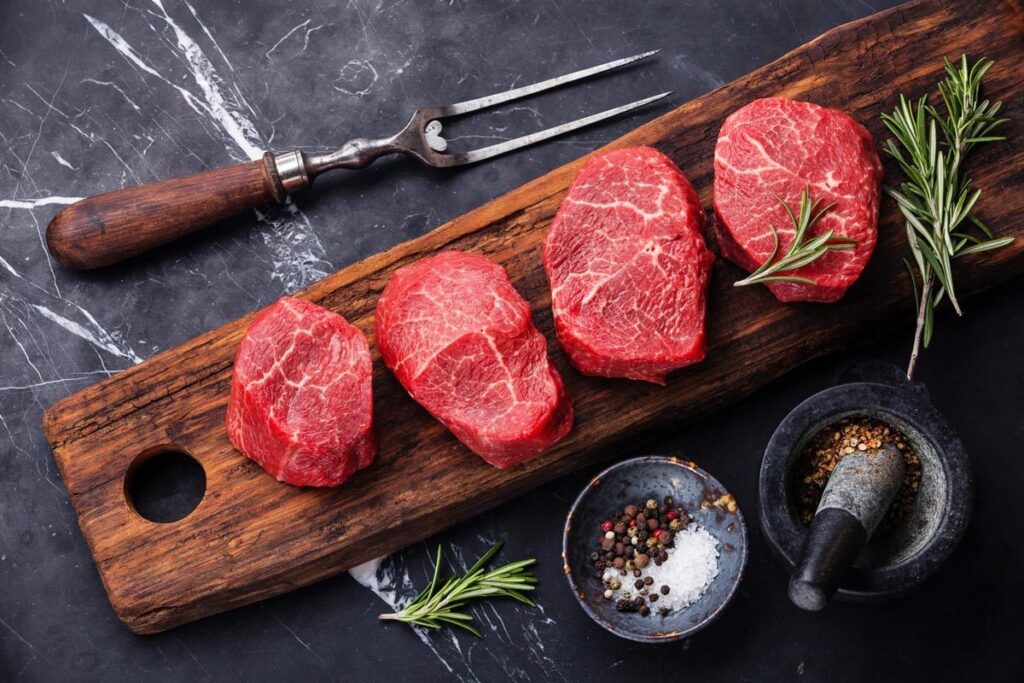 Sliced slabs of raw red meat.